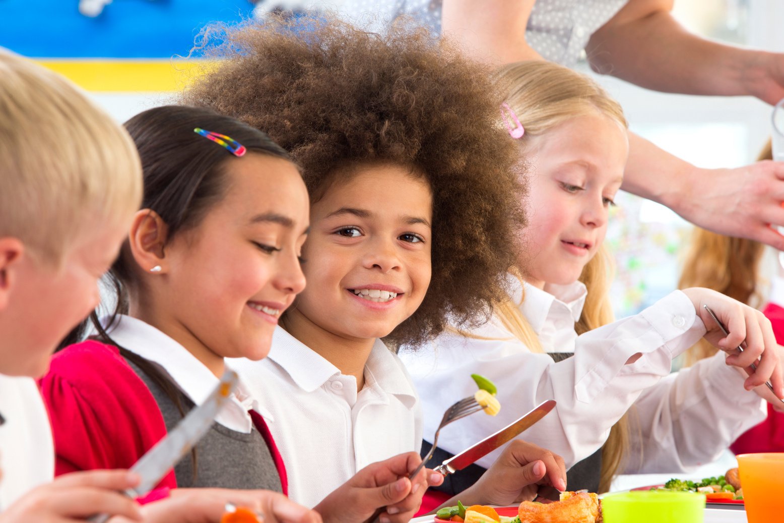 Happy children eating dinner at school